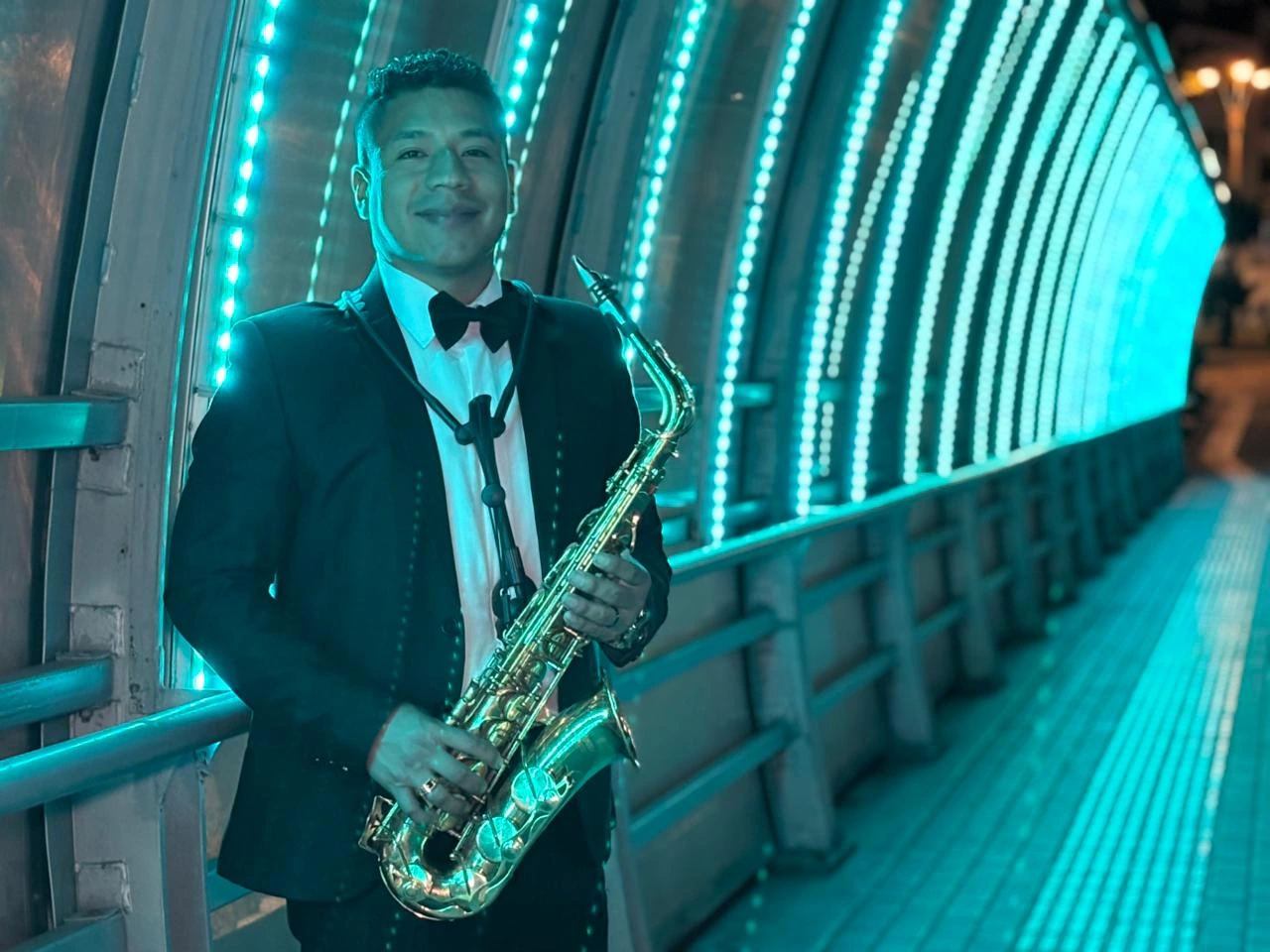 Cairo Sax con saxofón en una pasarela iluminada